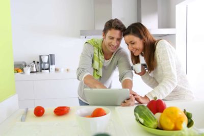 Couple in home kitchen looking for lunch recipe Küche