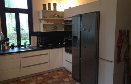 Küchenstudio Eine Küche mit Referenzen, einem Kühlschrank und einer Spüle.