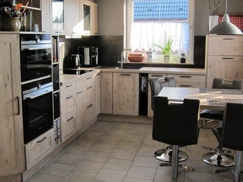 Küchenstudio Eine Küche mit Tisch und Stühlen, entworfen unter Berücksichtigung von Referenzen.