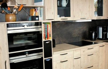 Küchenstudio Referenzen: Eine Küche mit Holzschränken und einer Mikrowelle.