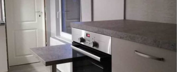 Küchenstudio Eine kleine Küche mit Herd und Backofen, ausgestattet mit hochwertigen Geräten.