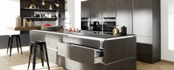 Küchenstudio Eine moderne Küche mit schwarzen Schränken und Holzböden.