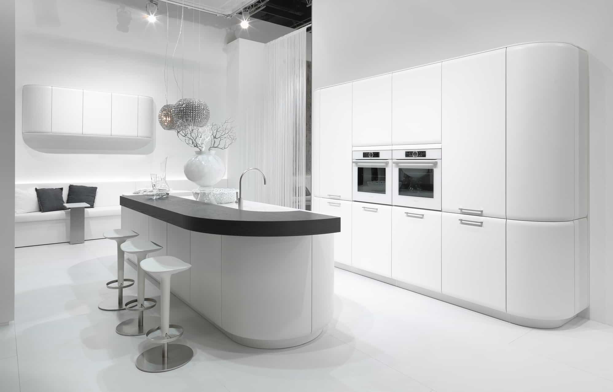 Küchenstudio Eine moderne Küche mit einer weißen Insel und Hockern.