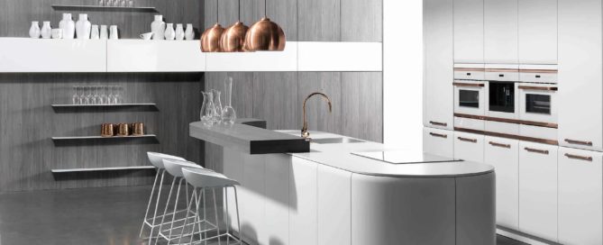 Küchenstudio Eine moderne Küche mit weißen Schränken und Kupferhockern.