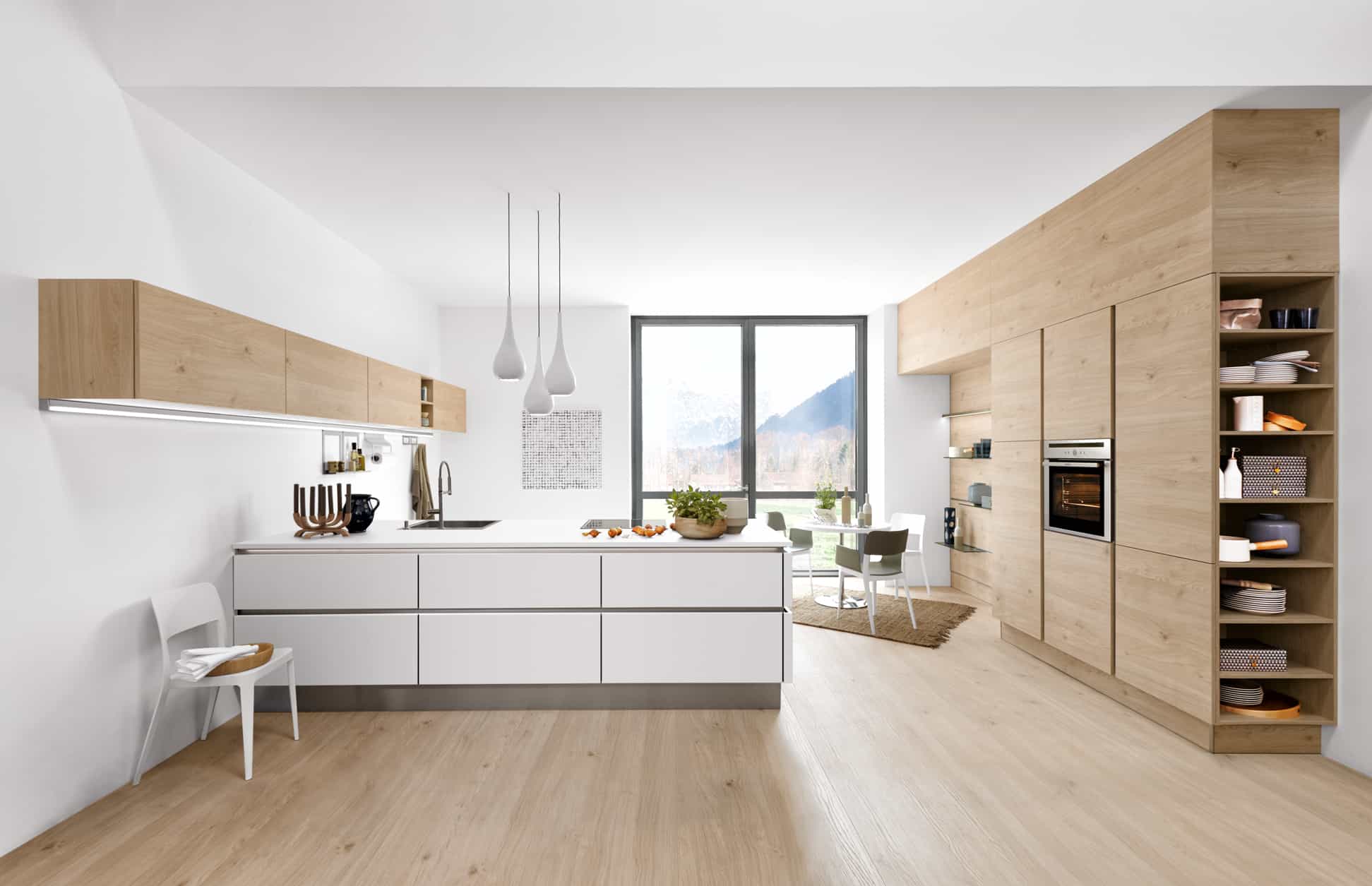 Küchenstudio Eine Küche in Weiß und Holz mit Holzboden.