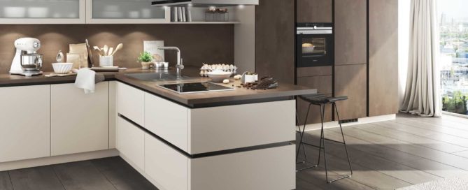 Küchenstudio Eine moderne Küche mit weißen Schränken und Holzböden.