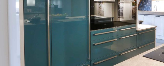 Küchenstudio Eine Küche mit blauen Schränken und Küchengeräten aus Edelstahl.