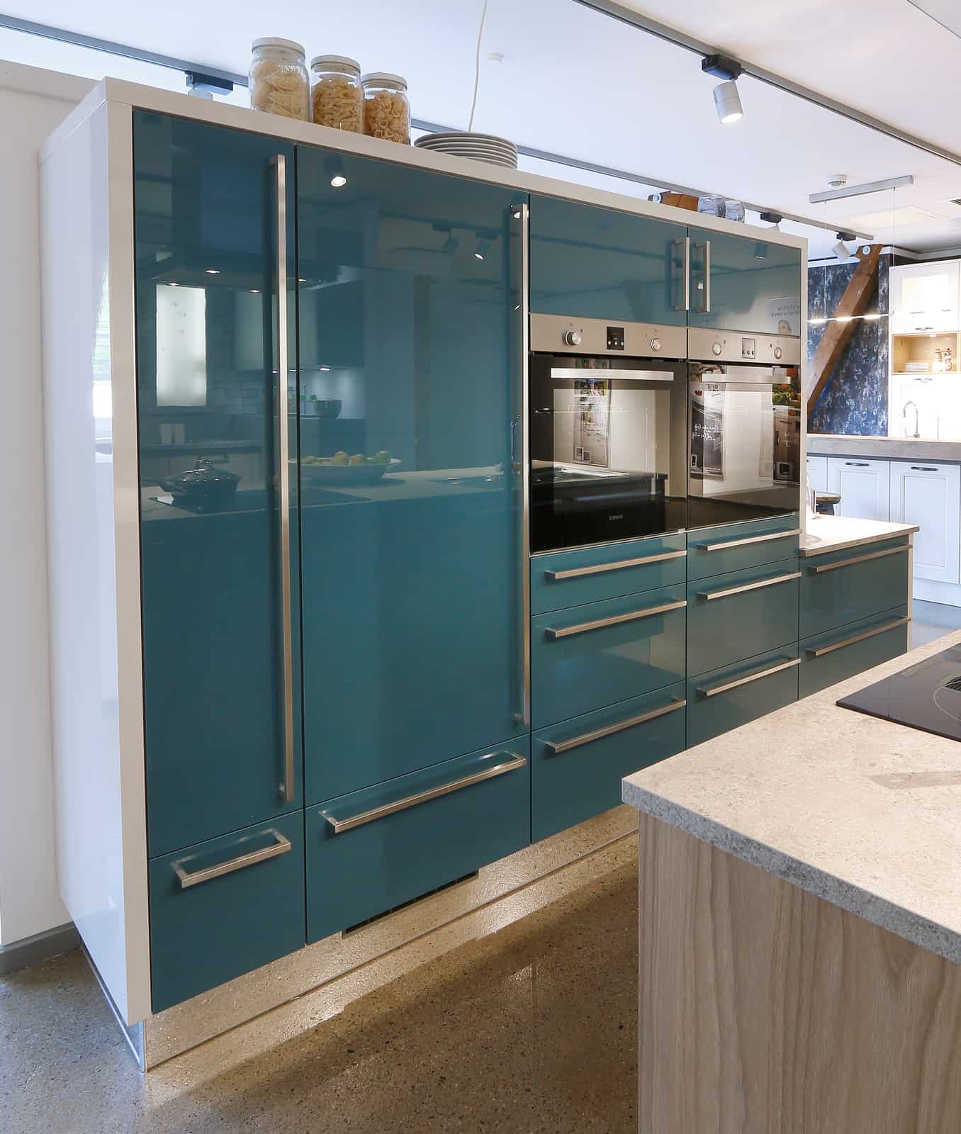 Küchenstudio Eine Küche mit blauen Schränken und Küchengeräten aus Edelstahl. Küchenstudio Eine Küche mit blauen Schränken und Küchengeräten aus Edelstahl.