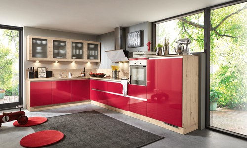 Küchenstudio Eine moderne Küche mit roten Schränken und Holzboden.