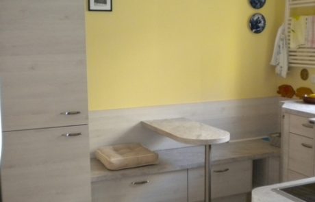 Küchenstudio Eine kleine Küche mit gelben Wänden und einem Holztisch, perfekt für Ihre Referenzen.