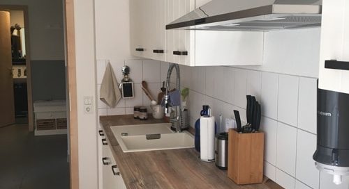 Küchenstudio Eine kleine Küche mit Herd und Spüle, ausgestattet mit modernen Referenzen.