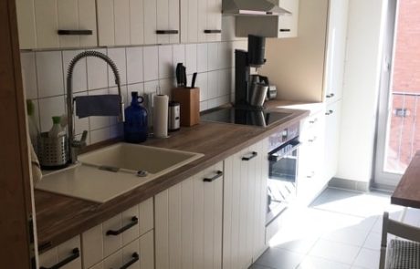Küchenstudio Eine kleine Küche mit weißen Schränken und einer Spüle mit Referenzen