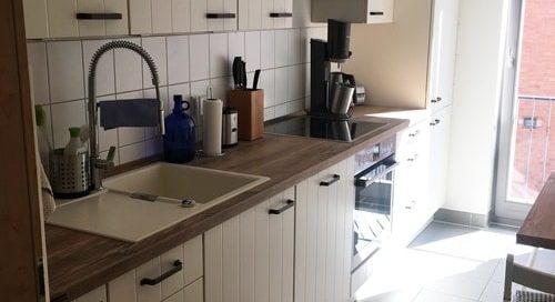 Küchenstudio Eine kleine Küche mit weißen Schränken und einer Spüle mit Referenzen