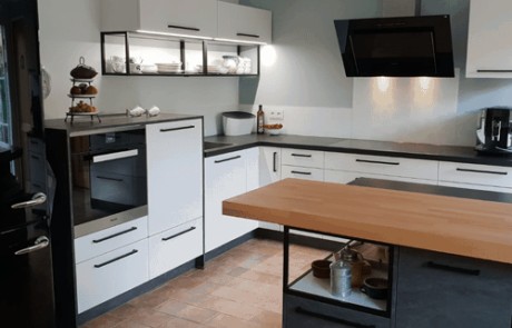 Küchenstudio Eine schwarz-weiße Küche mit Holzboden als Referenz.