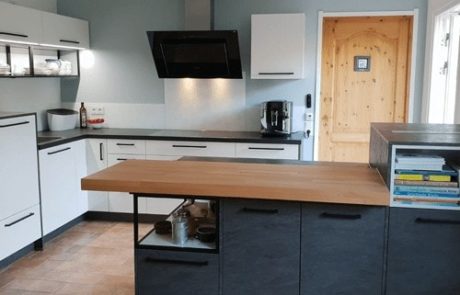 Küchenstudio Referenzen: Eine Küche mit weißen Schränken und einer Arbeitsplatte aus Holz.