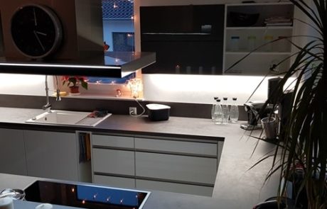 Küchenstudio Referenzen: Eine Küche mit weißer Arbeitsplatte und schwarzen Geräten, die als visuelle Referenz für eine stilvolle Inneneinrichtung dient.