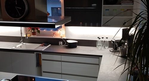 Küchenstudio Referenzen: Eine Küche mit weißer Arbeitsplatte und schwarzen Geräten, die als visuelle Referenz für eine stilvolle Inneneinrichtung dient.