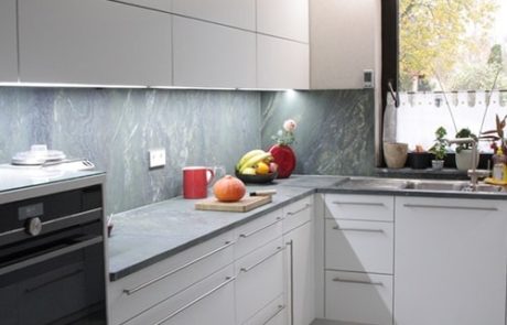 Küchenstudio Eine Küche mit weißen Schränken und einem Fenster, ideal für Referenzen, die ihre Arbeit präsentieren.