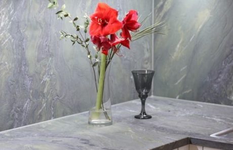 Küchenstudio Eine Küche mit Marmoroberflächen und einer Blumenvase, die unsere exquisiten Referenzen präsentiert.