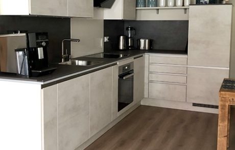 Küchenstudio Referenzen: Eine Küche mit weißen Schränken und Holzböden.