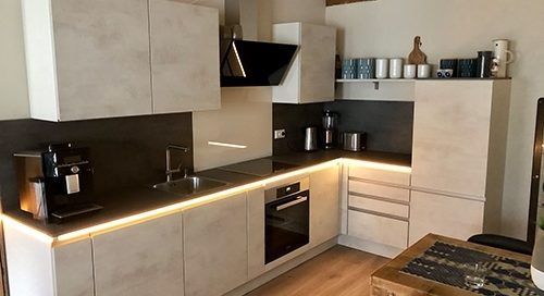 Küchenstudio Referenzen: Eine gemütliche Küche mit Tisch und Stühlen.