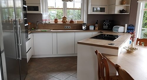 Küchenstudio Eine Küche mit Tisch und Stühlen und Referenzen.