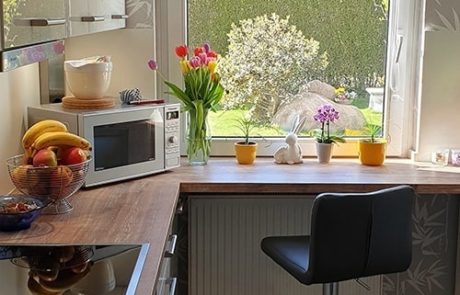 Küchenstudio Eine Küche mit einer Mikrowelle und einem Fenster.