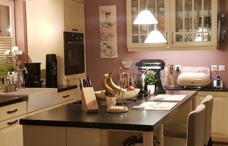 Küchenstudio Eine Küche mit lila Wänden und schwarzen Arbeitsplatten, inspiriert von modernem Design und mit exquisitem Geschmack dekoriert.