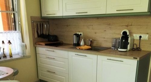 Küchenstudio Eine kleine Küche mit Tisch und Stühlen, ideal zum Nachdenken.