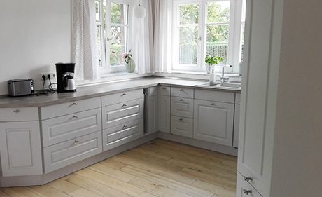 Küchenstudio Eine Küche mit weißen Schränken und einem Fenster, perfekt für diejenigen, die Referenzen benötigen.