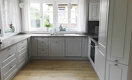 Küchenstudio Eine Küche mit weißen Schränken und einem Fenster, perfekt für Referenzen.