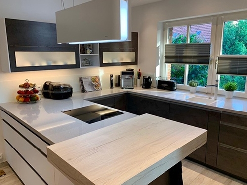 Küchenstudio Eine moderne Küche mit Holzschränken und weißen Arbeitsplatten im modernen Referenzen-Stil. Küchenstudio Eine moderne Küche mit Holzschränken und weißen Arbeitsplatten im modernen Referenzen-Stil.