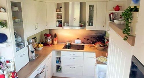 Küchenstudio Referenzen: Eine Küche mit weißen Schränken und Holzboden.