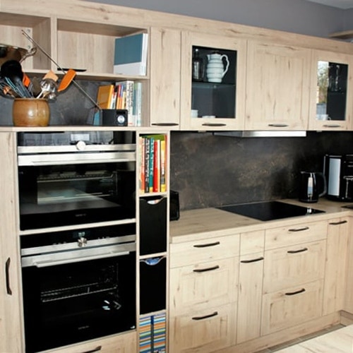 Küchenstudio Eine Küche mit Holzschränken und einer Mikrowelle. Die Holzschränke und der Mikrowellenherd sind hochwertige Referenzen für dieses moderne Küchendesign.