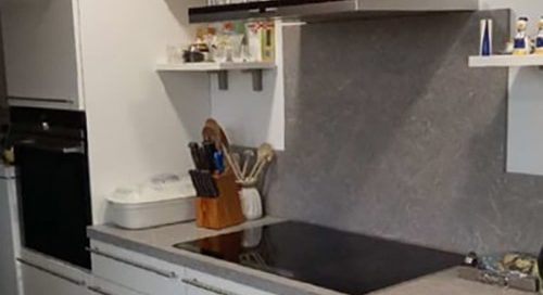 Küchenstudio Ein Referenzen mit Herd und Regalen.