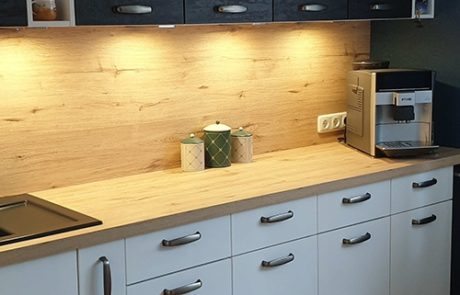 Küchenstudio Eine Küche mit weißen Schränken und schwarzen Arbeitsplatten, die als stilvolle und zeitlose Referenz für moderne Innenarchitektur dient.