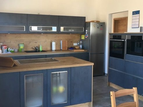 Küchenstudio Referenzen: Eine Küche mit blauen Schränken und Holzarbeitsplatten.