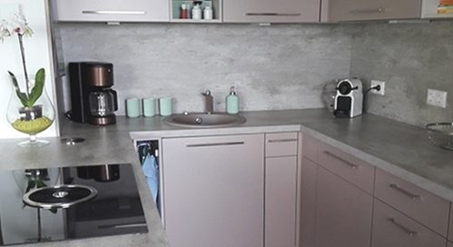 Küchenstudio Eine kleine Küche mit grauen Schränken und einer Mikrowelle.