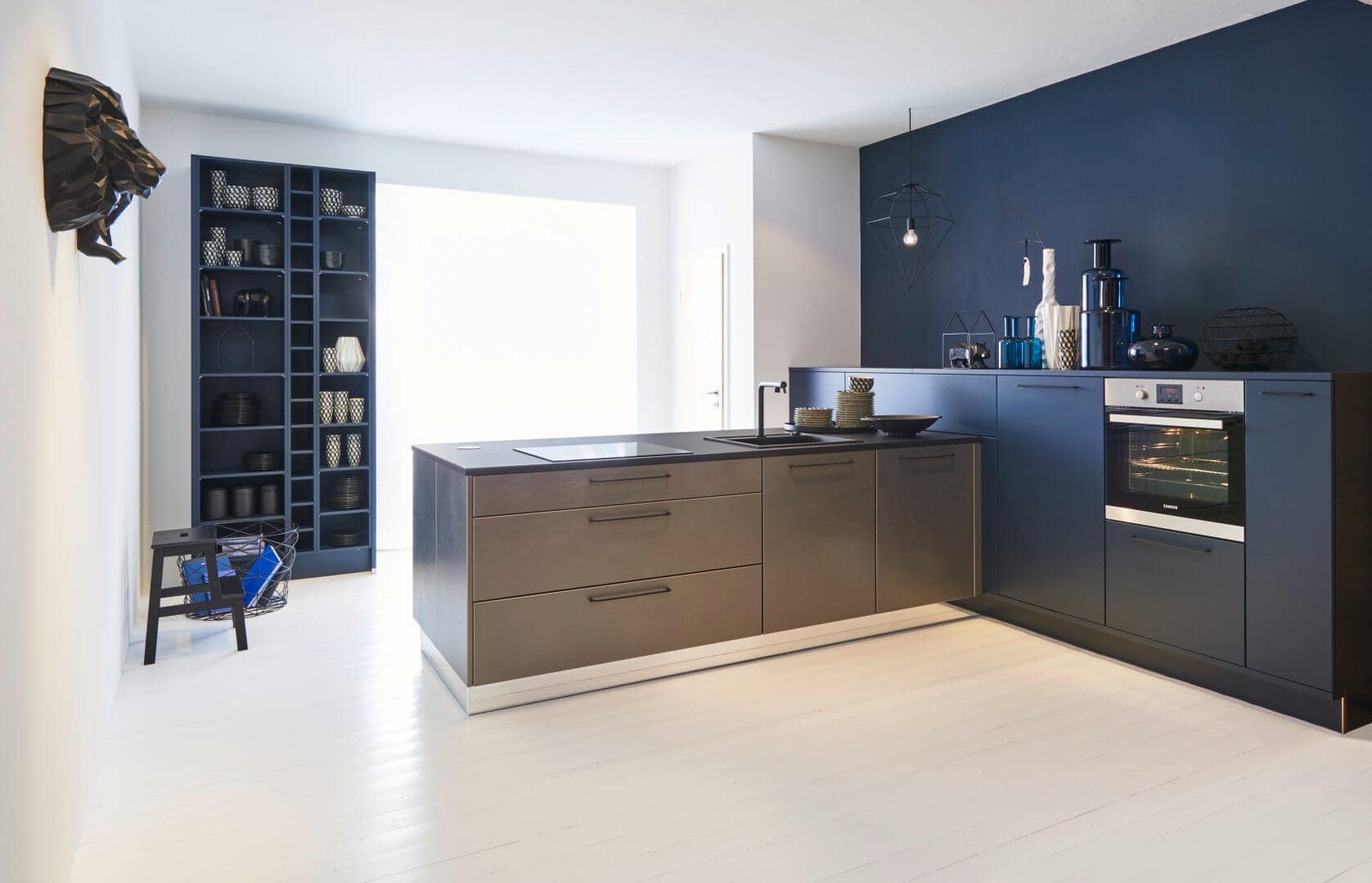 Küchenstudio Eine moderne Küche mit blauen Wänden und Holzböden.