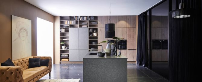 Küchenstudio Eine moderne Küche mit schwarzen Schränken und einer Ledercouch.