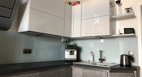 Küchenstudio Referenzen: Eine Küche mit grauen Schränken und Geräten aus Edelstahl.
