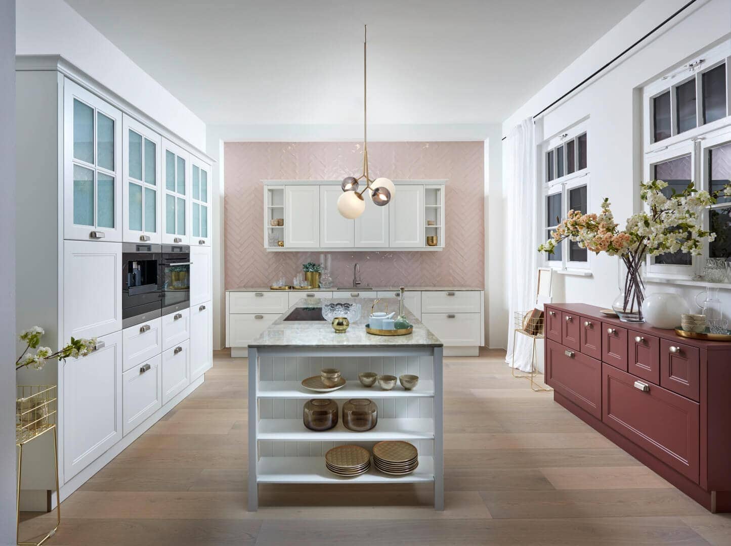 Küchenstudio Eine Küche mit weißen Schränken und einer rosa Kücheninsel. Küchenstudio Eine Küche mit weißen Schränken und einer rosa Kücheninsel.