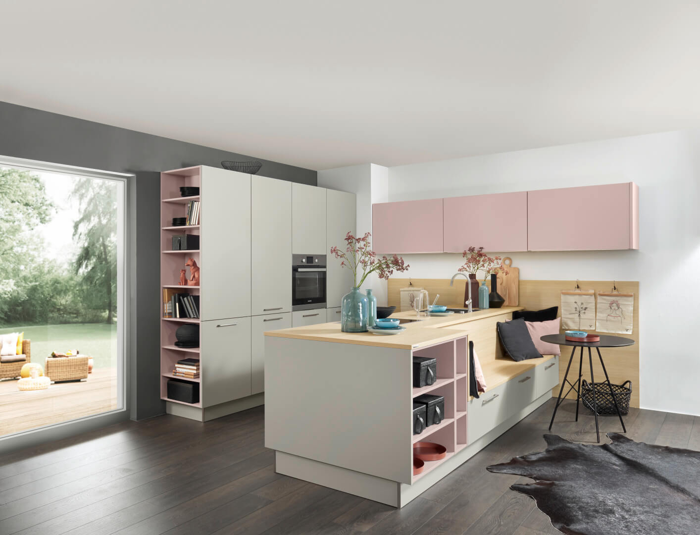 Küchenstudio Eine rosa-weiße Küche mit Holzboden.