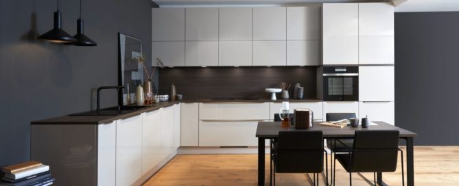 Küchenstudio Eine moderne Küche mit weißen Schränken und Holzböden.