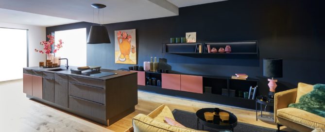 Küchenstudio Eine moderne Küche mit schwarzen Wänden und einer gelben Couch.
