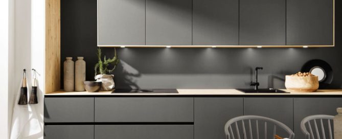 Küchenstudio Eine moderne Küche mit grauen Schränken und Holzböden.