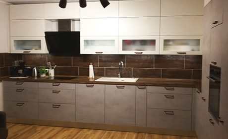 Küchenstudio Eine Küche mit weißen Schränken und Holzböden.
