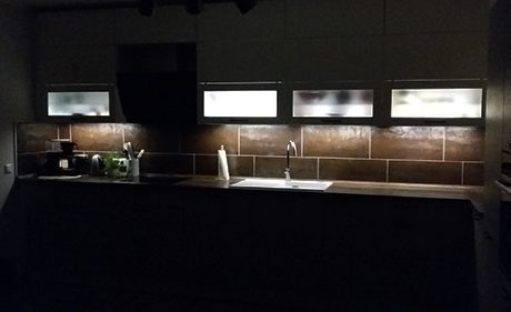 Küchenstudio Eine Küche mit Spüle und Licht im Dunkeln.