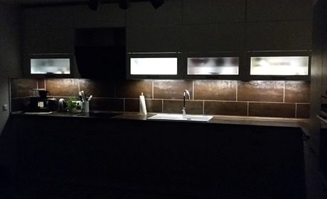 Küchenstudio Eine Küche mit Spüle und Licht im Dunkeln.