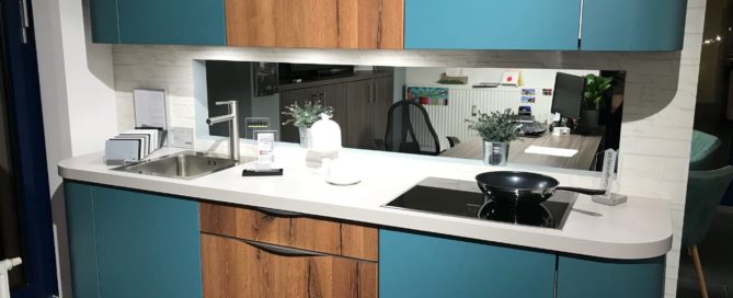 Küchenstudio Eine blaue und hölzerne Küche in einem Abverkauf-Laden.